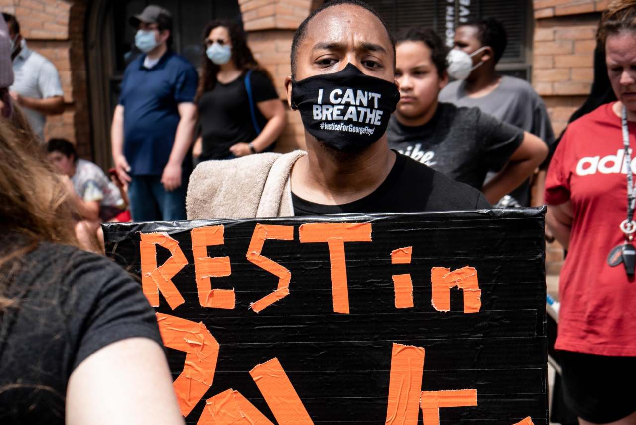 image: black lives matter masked protestor rest in power placard