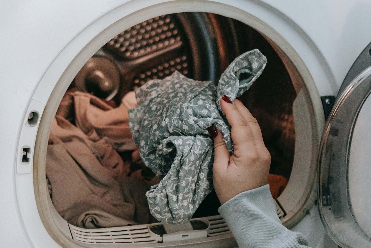 Person putting clothes in washing machine
