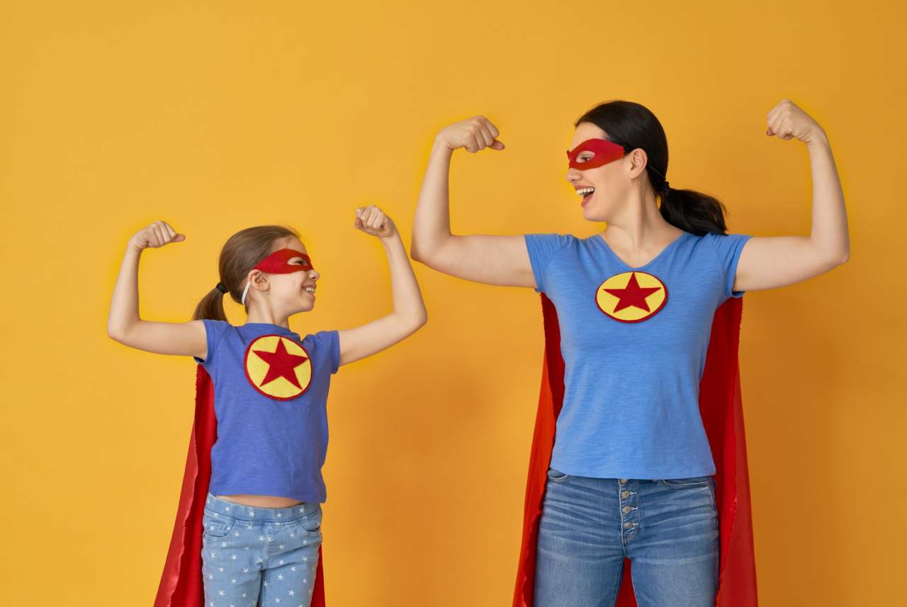 Woman and child in superhero capes and t-shirts