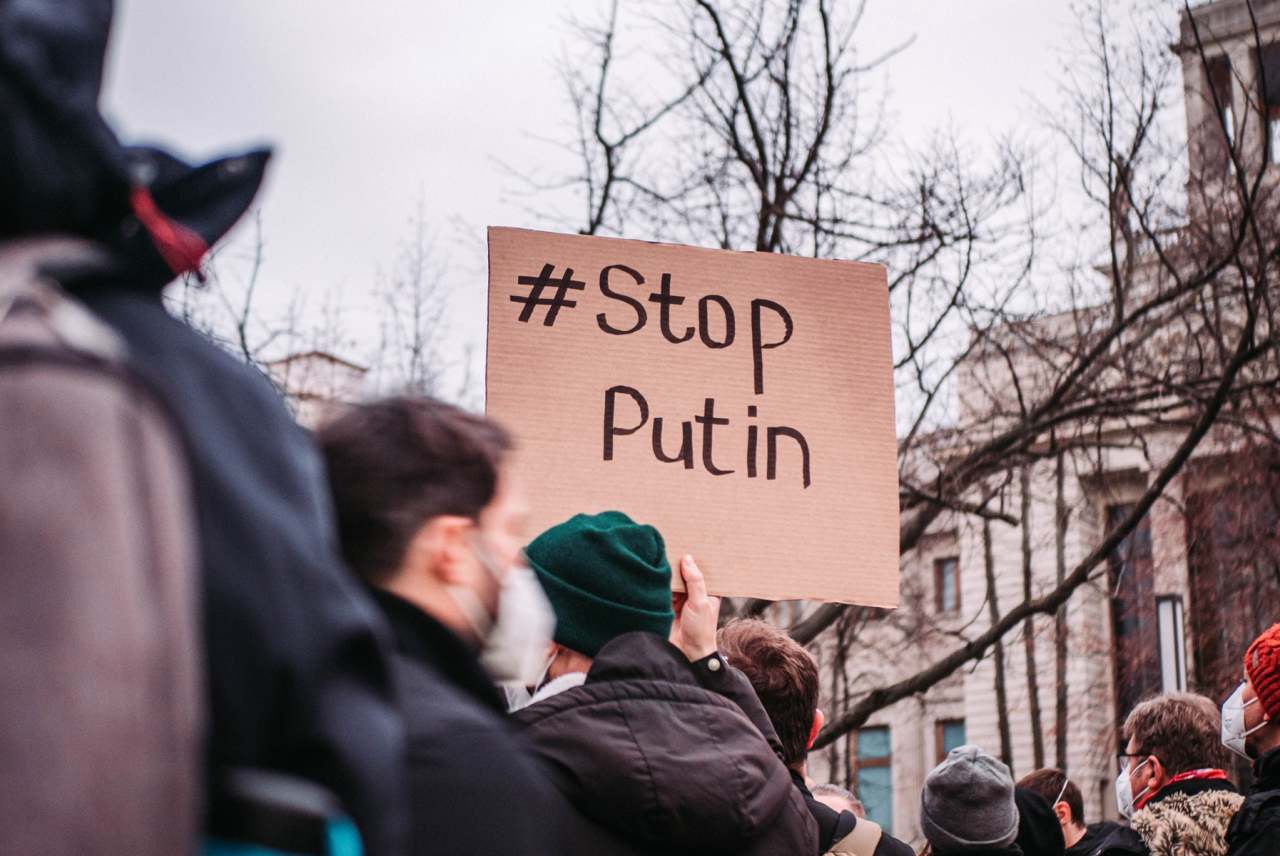 Demonstrators protesting Russian invasion of Ukraine with placard which says Stop Putin