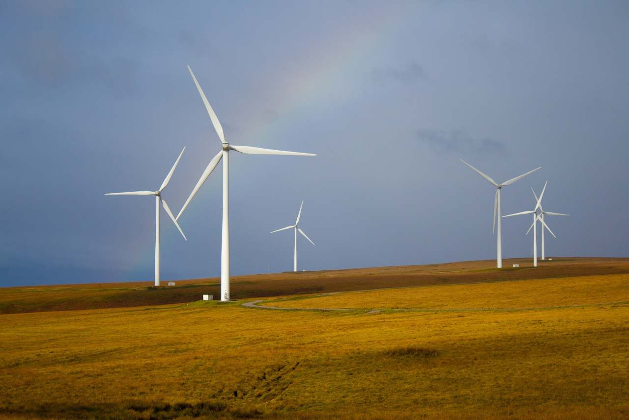 Windmills on hillside with rainbow