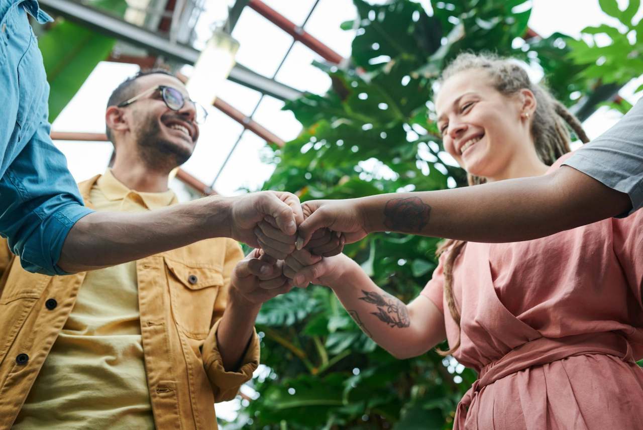 Four young people fist bumping in circle
