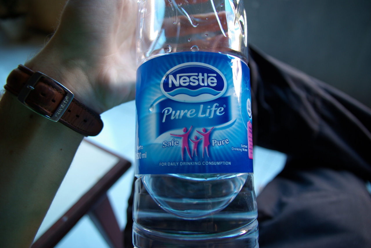 Person's hand holding Nestle water bottle