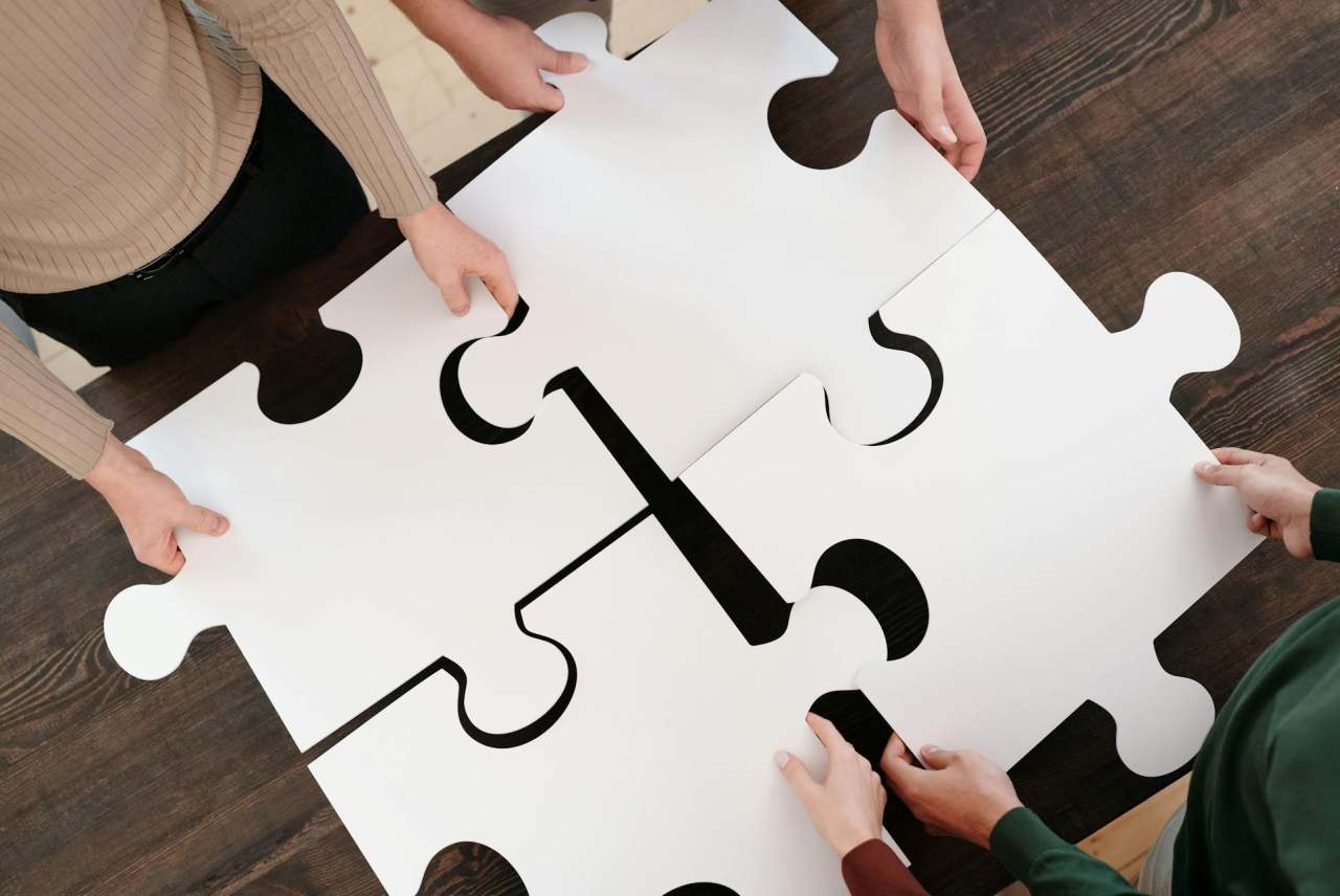 People holding large jigsaw pieces slotting together