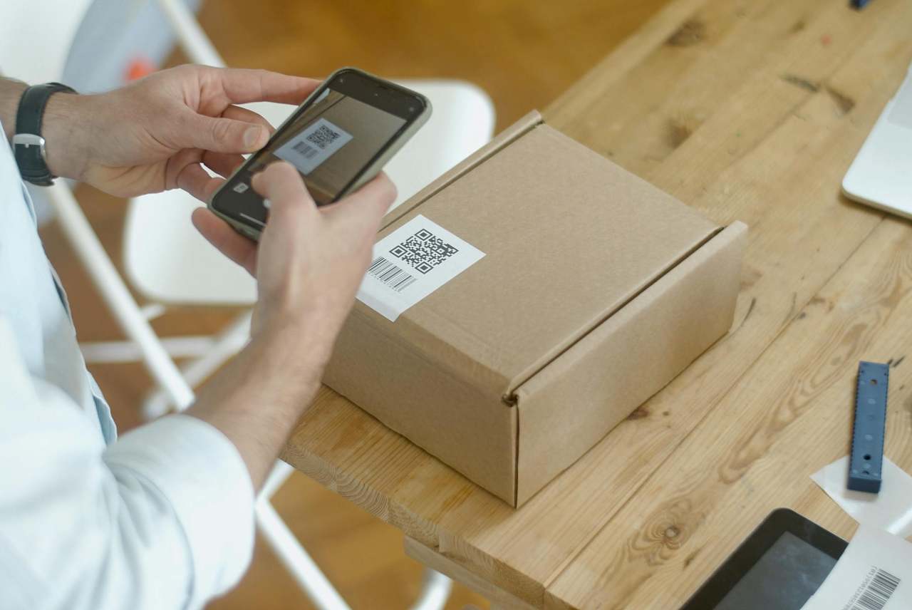 Person taking picture of QR code on a small parcel