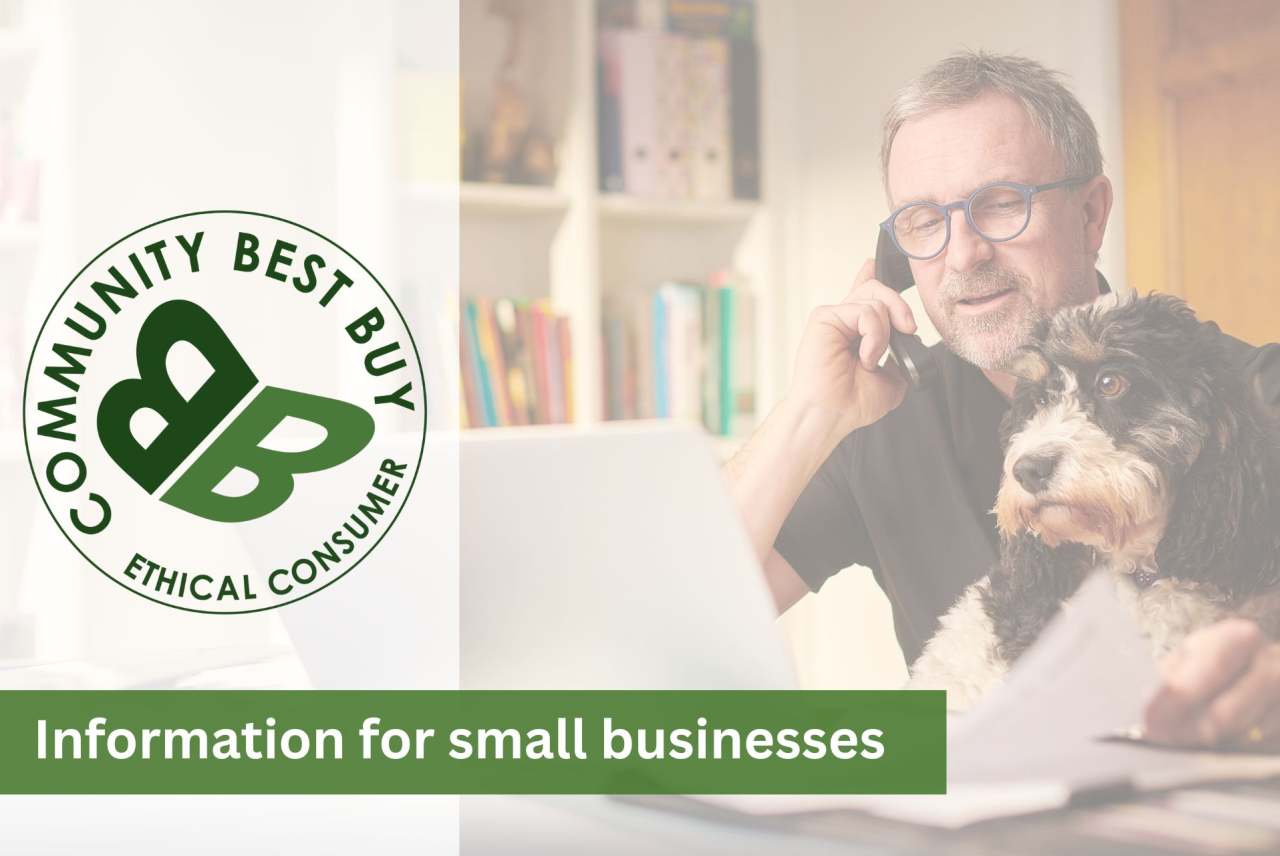 Man at laptop talking on mobile phone, with dog on his lap