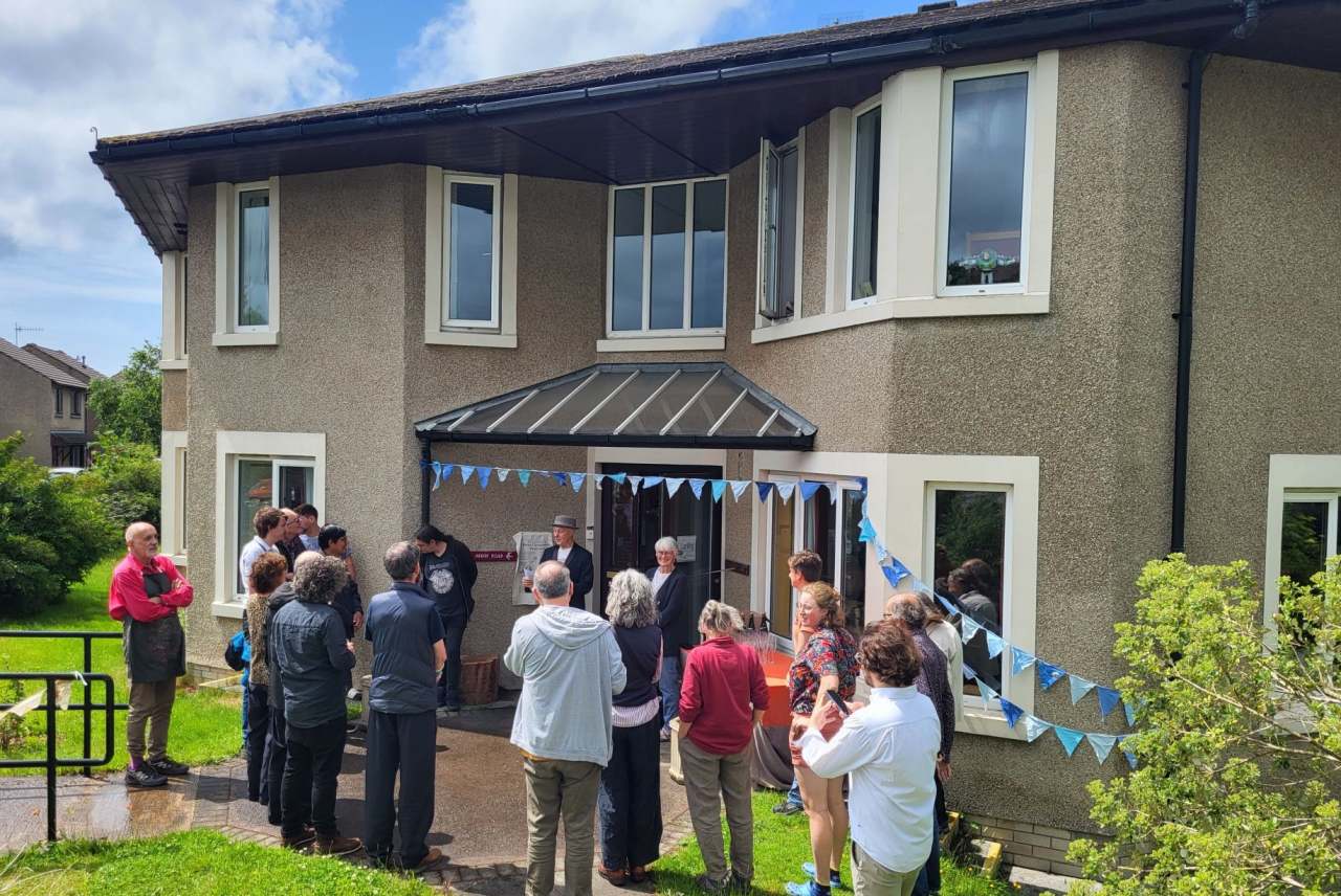 Group of people standing outside house 