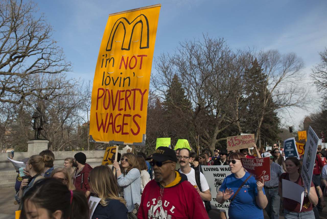 Crowd protest, one banner reads "I'm not lovin poverty wages"