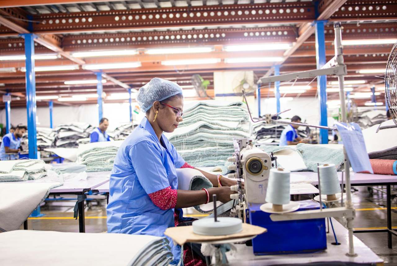 Woman sews fabric at an industrial sewing machine.