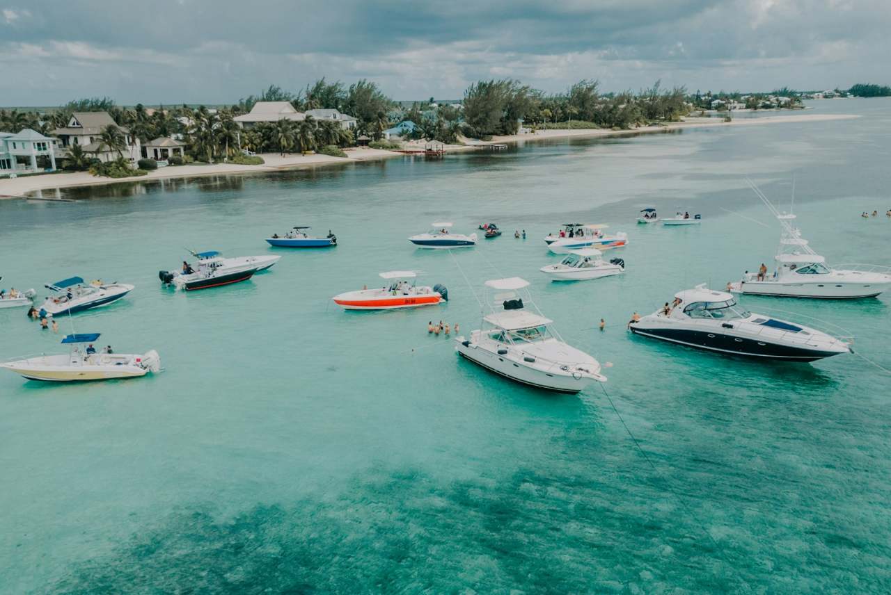 Yachts and speed boats in tropical waters with beach coastline