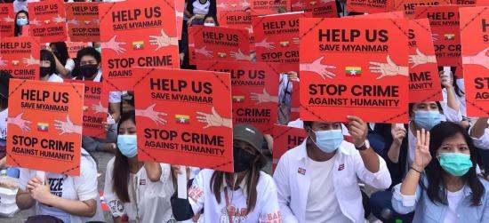 Crowd of people protesting with placards crime humanity Burma