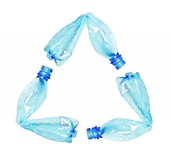 Three empty clear plastic bottles, each bent in half, laid out to create a triangle like the recycling logo
