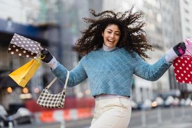 Happy woman holding lots of shopping bags