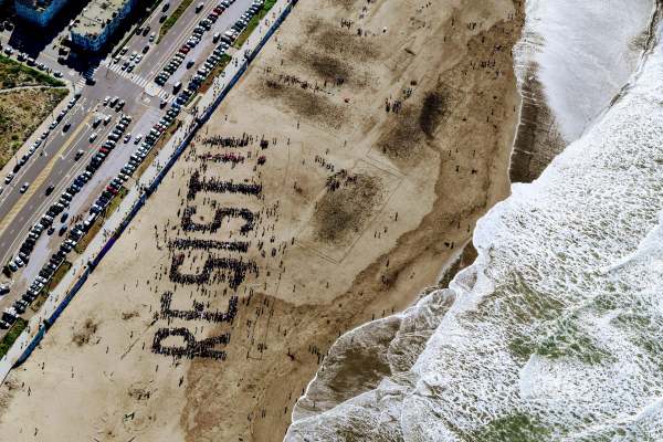 Aerial view of beach with people forming the word Resist!