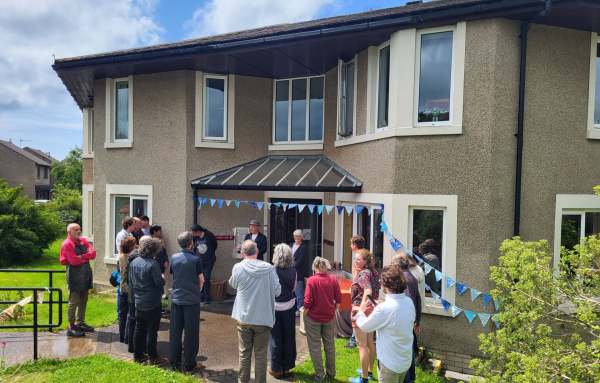 Group of people standing outside house 